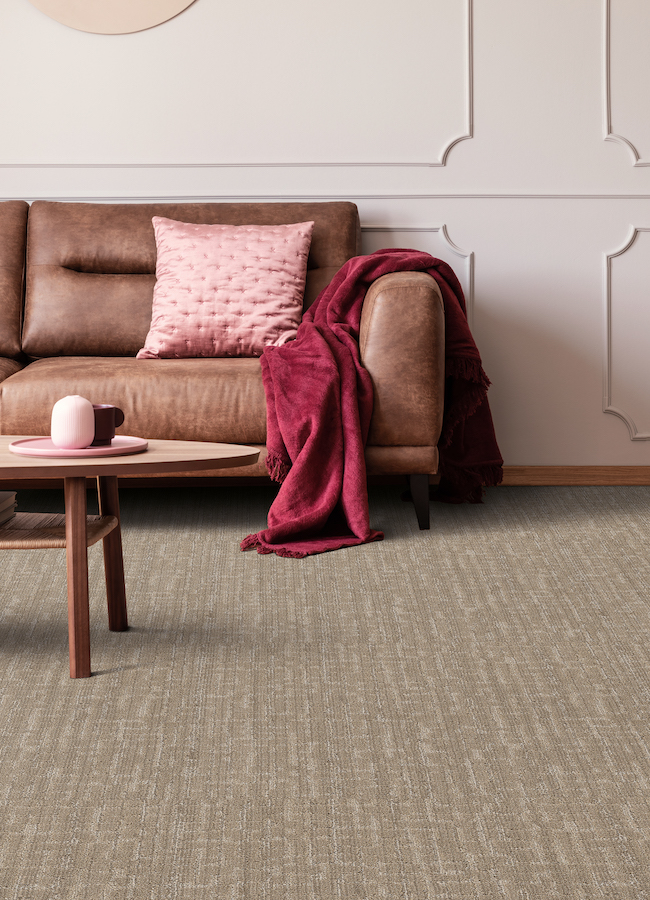 stylish brown textured carpets in a modern living room with brown leather couch and pink accents